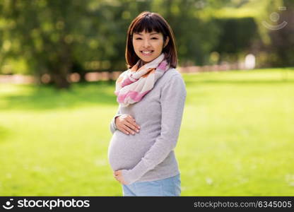 pregnancy, people and motherhood concept - happy pregnant asian woman at park. happy pregnant asian woman at park