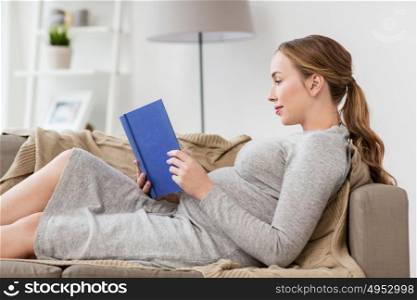 pregnancy, people and motherhood concept - smiling pregnant woman lying on sofa and reading book. happy pregnant woman reading book at home