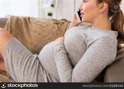 pregnancy, people and technology concept - close up of happy pregnant woman calling on smartphone at home. happy pregnant woman calling on smartphone at home