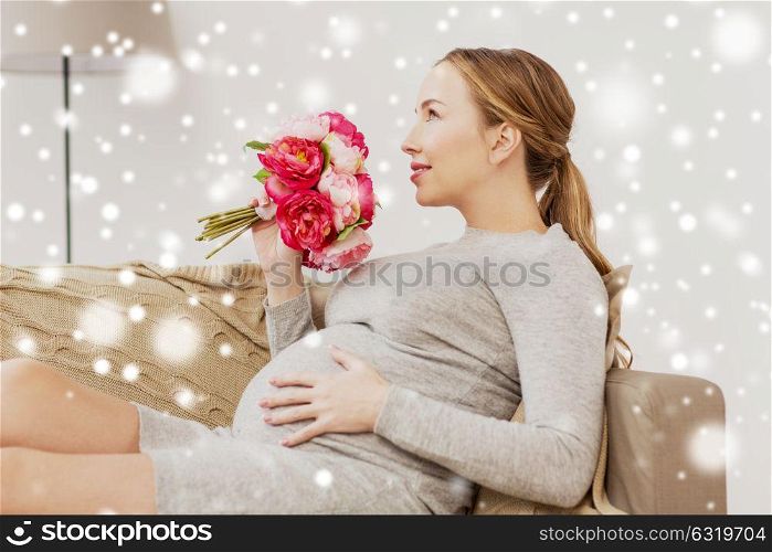 pregnancy, people, holidays and expectation concept - happy pregnant woman with flowers at home over snow. happy pregnant woman with flowers at home