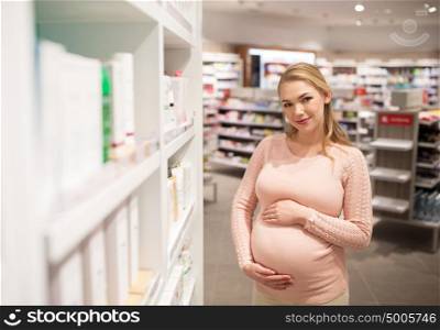 pregnancy, people, medicine, healthcare and beauty concept - happy smiling pregnant woman at pharmacy or cosmetics store. pregnant woman at pharmacy or cosmetics store