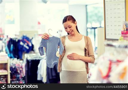 pregnancy, people, sale and expectation concept - happy pregnant woman shopping and buying baby bodysuit at children clothing store
