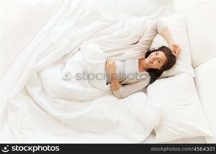 pregnancy, rest, people and expectation concept - happy pregnant woman lying in bed at home bedroom