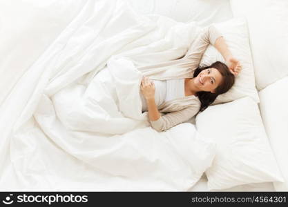 pregnancy, rest, people and expectation concept - happy pregnant woman lying in bed at home bedroom