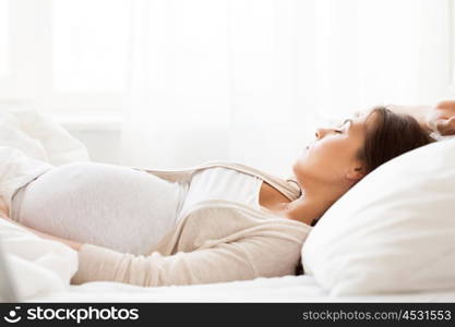 pregnancy, rest, people and expectation concept - happy pregnant woman sleeping in bed at home