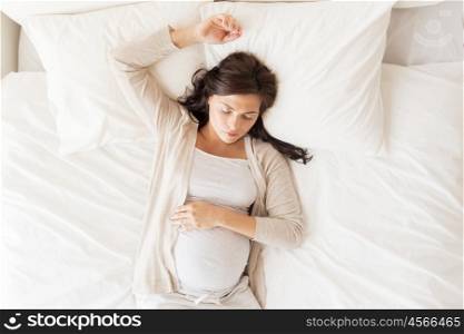 pregnancy, rest, people and expectation concept - happy pregnant woman sleeping in bed at home