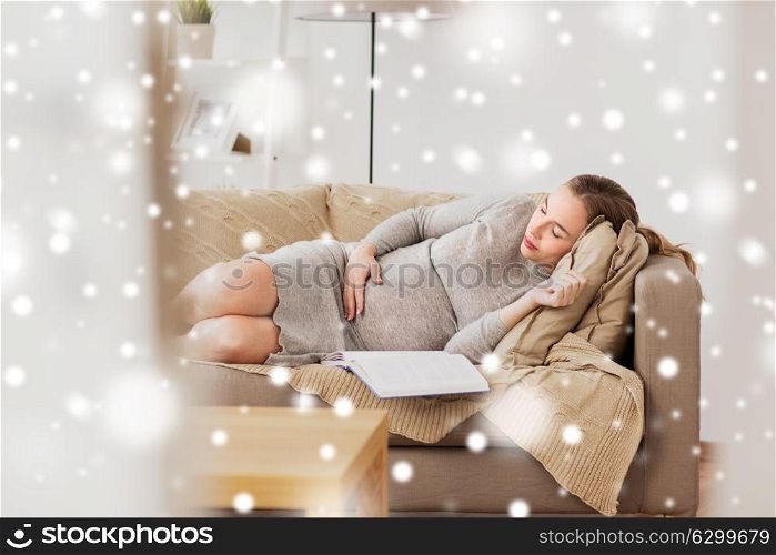 pregnancy, rest, people and expectation concept - happy pregnant woman sleeping on sofa at home over snow. happy pregnant woman sleeping on sofa at home