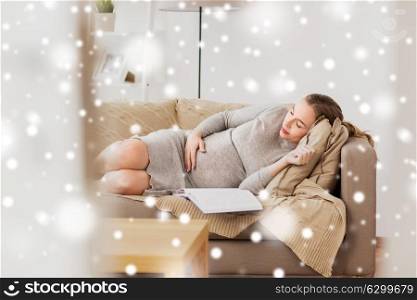 pregnancy, rest, people and expectation concept - happy pregnant woman sleeping on sofa at home over snow. happy pregnant woman sleeping on sofa at home