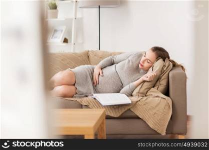 pregnancy, rest, people and expectation concept - happy pregnant woman sleeping on sofa at home. happy pregnant woman sleeping on sofa at home
