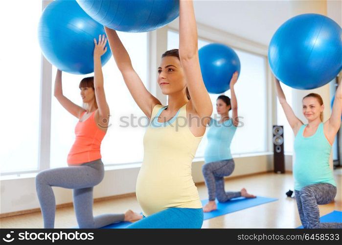 pregnancy, sport, fitness and healthy lifestyle concept - group of happy pregnant women training with exercise balls in gym. pregnant women training with exercise balls in gym