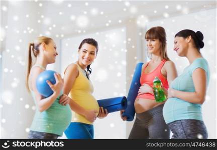 pregnancy, sport, fitness, people and healthy lifestyle concept - group of happy pregnant women with sports equipment talking in gym over snow