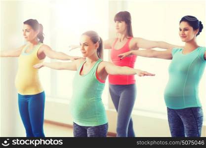 pregnancy, sport, fitness, people and healthy lifestyle concept - group of happy pregnant women exercising in gym. happy pregnant women exercising in gym