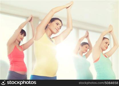 pregnancy, sport, fitness, people and healthy lifestyle concept - group of happy pregnant women exercising in gym. happy pregnant women exercising in gym. happy pregnant women exercising in gym