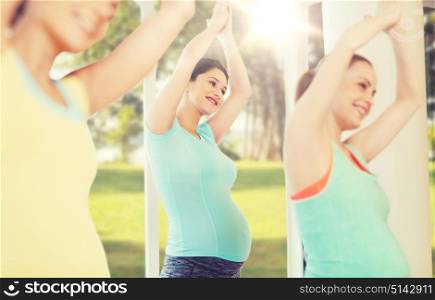 pregnancy, sport, fitness, people and healthy lifestyle concept - group of happy pregnant women exercising in gym over natural window view background. happy pregnant women exercising in gym