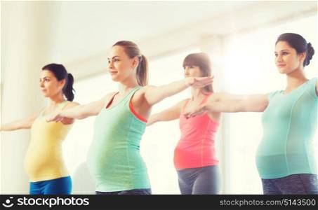 pregnancy, sport, fitness, people and healthy lifestyle concept - group of happy pregnant women exercising in gym. happy pregnant women exercising in gym