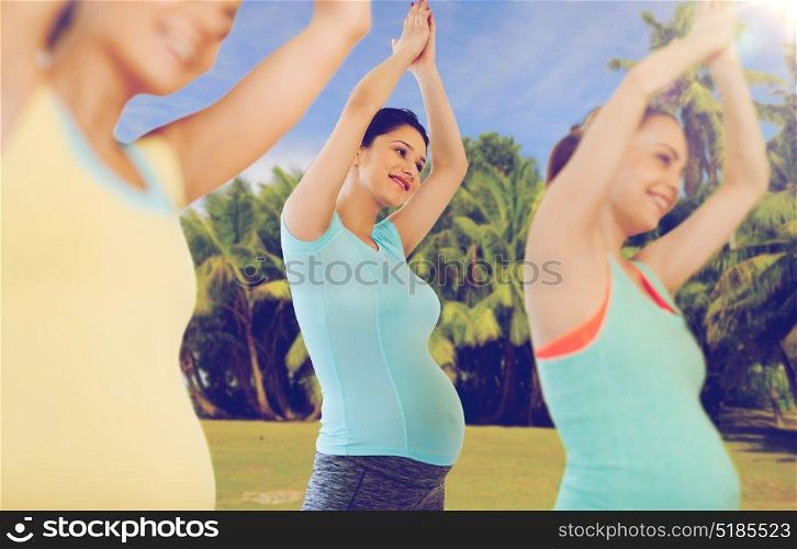 pregnancy, sport, fitness, people and healthy lifestyle concept - group of happy pregnant women exercising in gym. happy pregnant women exercising outdoors
