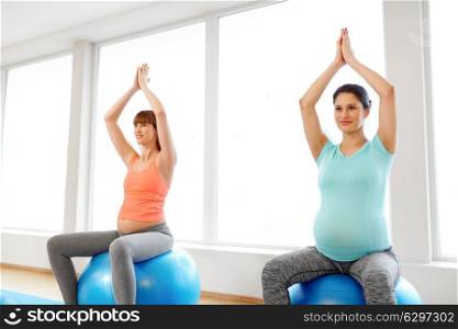 pregnancy, sport, fitness, people and healthy lifestyle concept - group of happy pregnant women sitting on exercise balls in gym. pregnant women sitting on exercise balls in gym. pregnant women sitting on exercise balls in gym