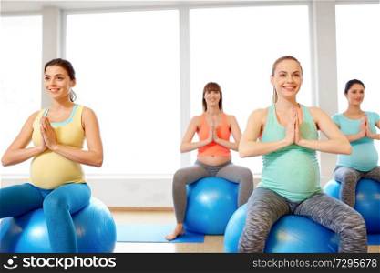 pregnancy, sport, fitness, people and healthy lifestyle concept - group of happy pregnant women sitting on exercise balls in gym. pregnant women sitting on exercise balls in gym