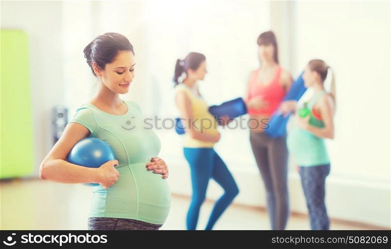 pregnancy, sport, fitness, people and healthy lifestyle concept - happy pregnant woman with ball in gym. happy pregnant woman with ball in gym