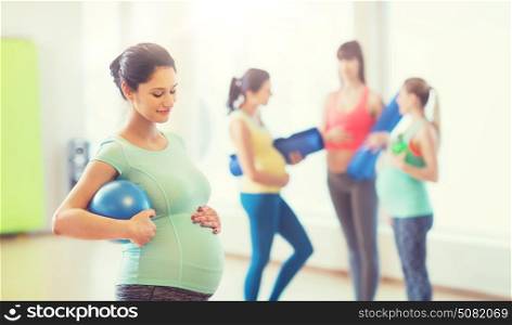pregnancy, sport, fitness, people and healthy lifestyle concept - happy pregnant woman with ball in gym. happy pregnant woman with ball in gym