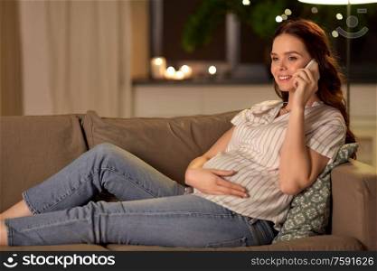 pregnancy, technology and people concept - happy pregnant woman calling on smartphone at home. happy pregnant woman calling on smartphone at home