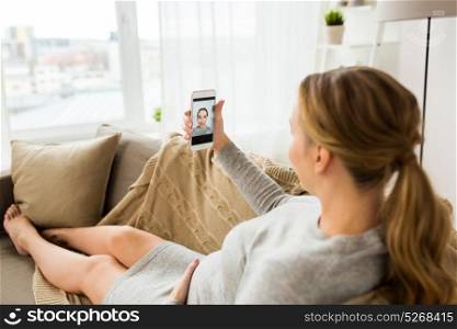 pregnancy, technology and people concept - happy pregnant woman with smartphone taking selfie at home. pregnant woman taking smartphone selfie at home