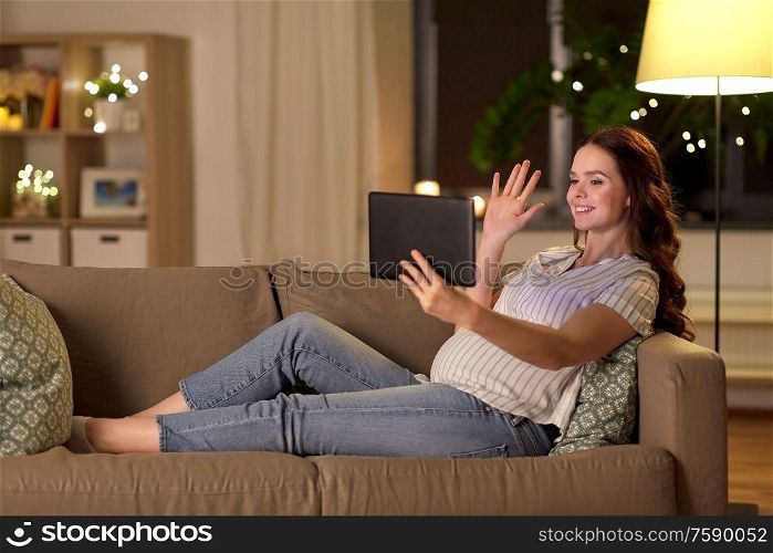 pregnancy, technology and people concept - happy pregnant woman with tablet pc computer having video call and waving hand at home. happy pregnant woman with tablet pc at home