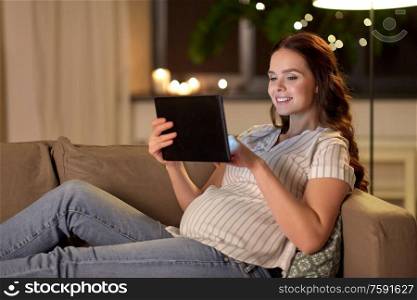 pregnancy, technology and people concept - happy pregnant woman with tablet pc computer at home. happy pregnant woman with tablet pc at home