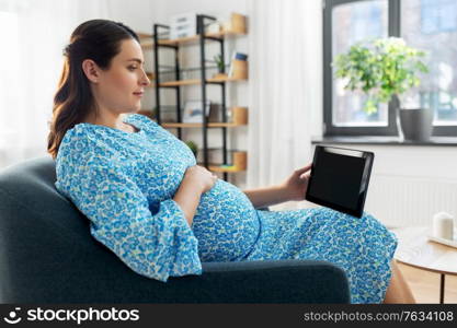 pregnancy, technology and people concept - happy pregnant woman with tablet pc computer at home. happy pregnant woman with tablet pc at home