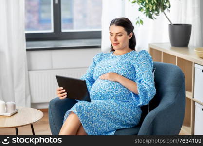 pregnancy, technology and people concept - happy pregnant woman with tablet pc computer at home. happy pregnant woman with tablet pc at home