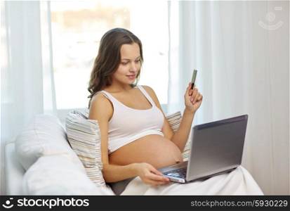 pregnancy, technology, people and expectation concept - happy pregnant woman with laptop and ultrasound image at home