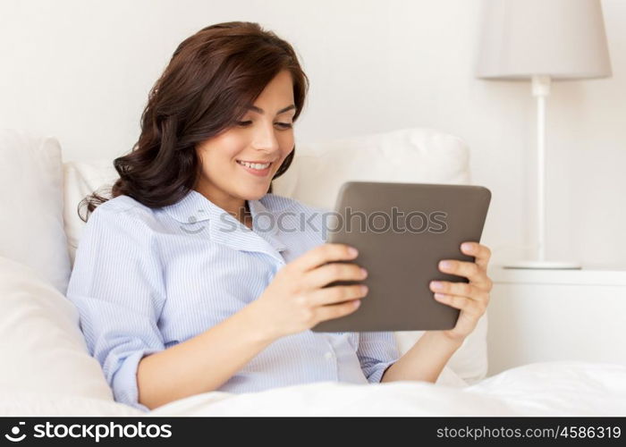pregnancy, technology, people and expectation concept - happy pregnant woman with tablet pc computer in bed at home