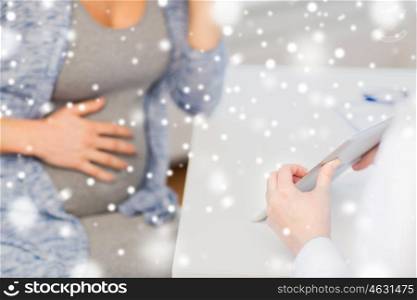 pregnancy, winter, medicine, healthcare and people concept - close up of gynecologist doctor showing tablet pc computer to pregnant woman at hospital over snow
