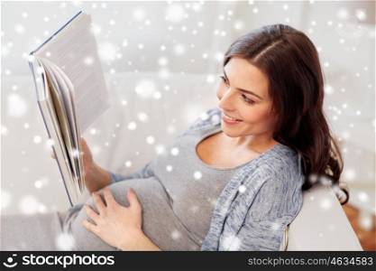 pregnancy, winter, people and motherhood concept - smiling pregnant woman lying on sofa and reading book over snow