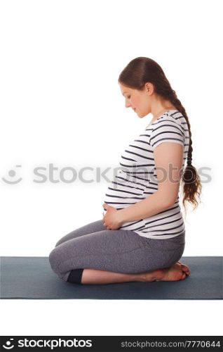 Pregnancy yoga exercise - pregnant woman doing yoga asana Virasana Hero Pose on knees isolated on white background. Pregnant woman doing yoga asana Virasana