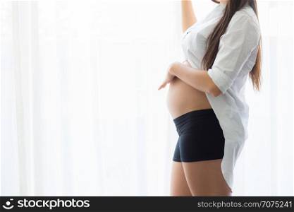Pregnant belly with hand holding care. Beautiful young woman pregnant - Love Concept.