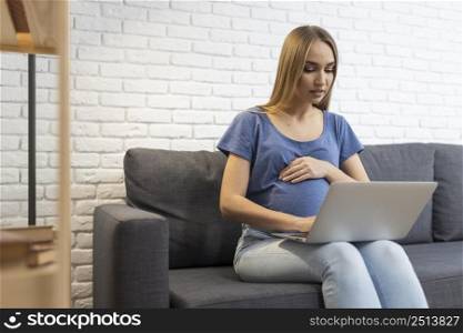 pregnant businesswoman sofa working with laptop