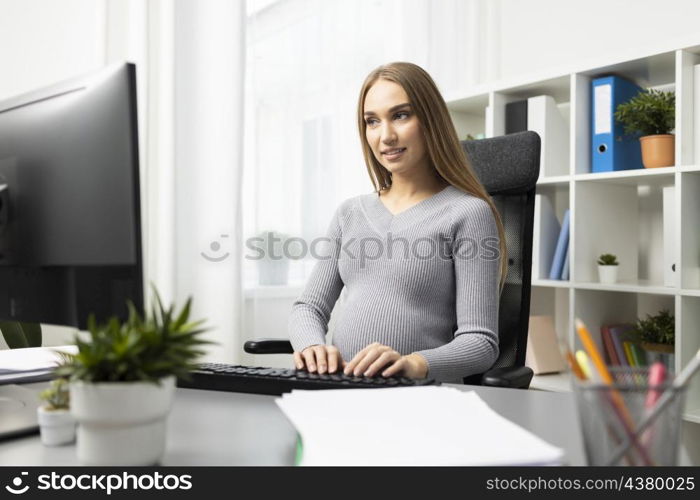 pregnant businesswoman working her desk computer