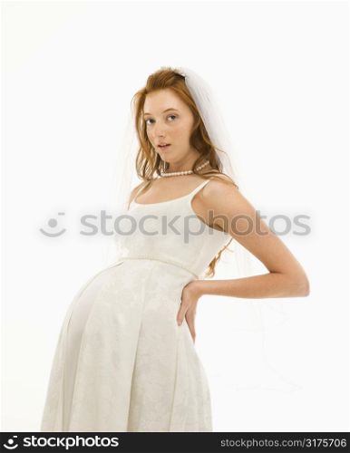 Pregnant Caucasian bride with hands on her back.