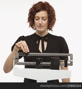 Pregnant Caucasian mid-adult woman reading her weight on scale.