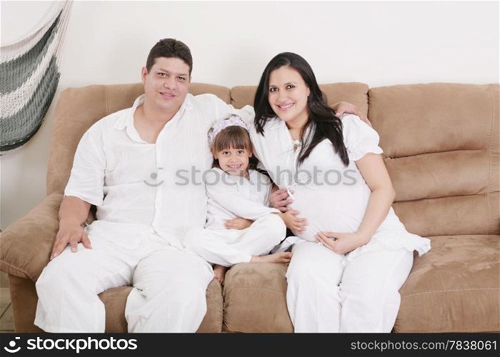 pregnant couple enjoying with their daughter