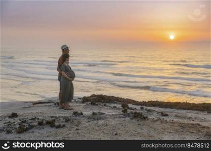 Pregnant couple on a wild  beach expecting a baby