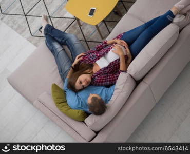pregnant couple relaxing on sofa. top view of happy pregnant couple relaxing on sofa couch at home