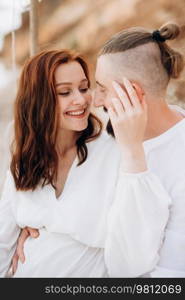 pregnant girl and boyfriend on a picnic by the sea in white clothes