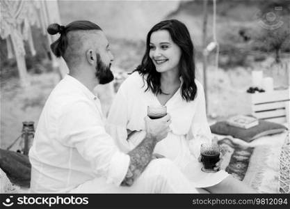 pregnant girl and boyfriend on a picnic by the sea in white clothes