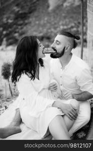 pregnant girl and boyfriend on a picnic by the sea in white clothes