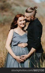 pregnant girl and boyfriend on high hills near the sea