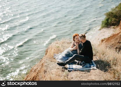 pregnant girl and boyfriend on high hills near the sea
