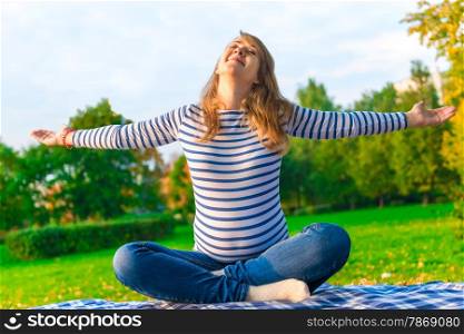 pregnant girl is preparing for the birth. doing breathing exercises on the nature