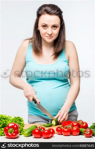 pregnant girl preparing from fresh healthy vegetable salad